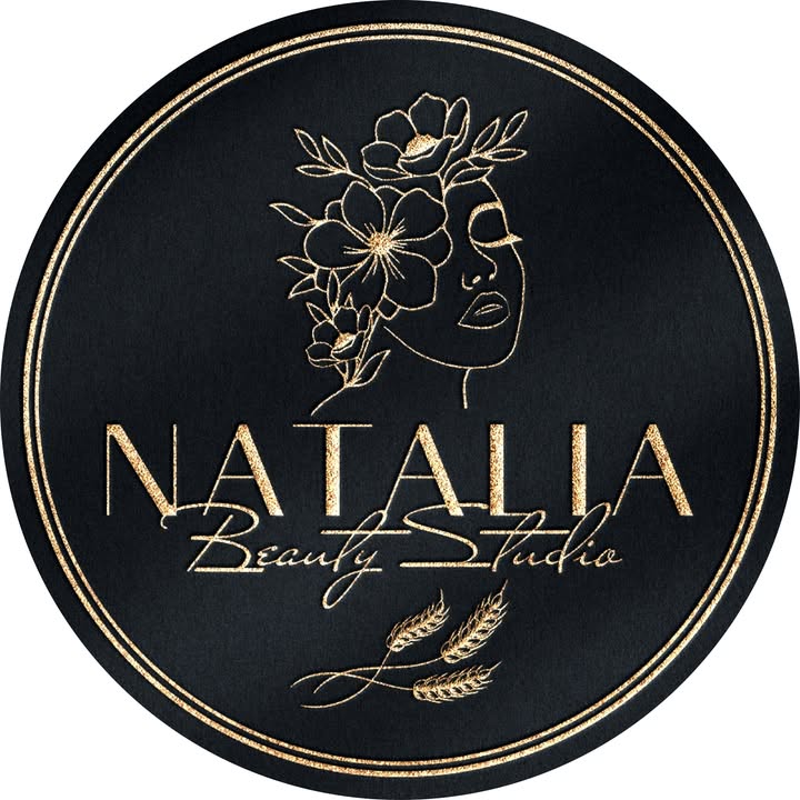Het logo van Natalia Beauty Studio: een zwarte cirkel met een dubbele gouden ring, een getekend vrouwenprofiel met bloemen en korenaren