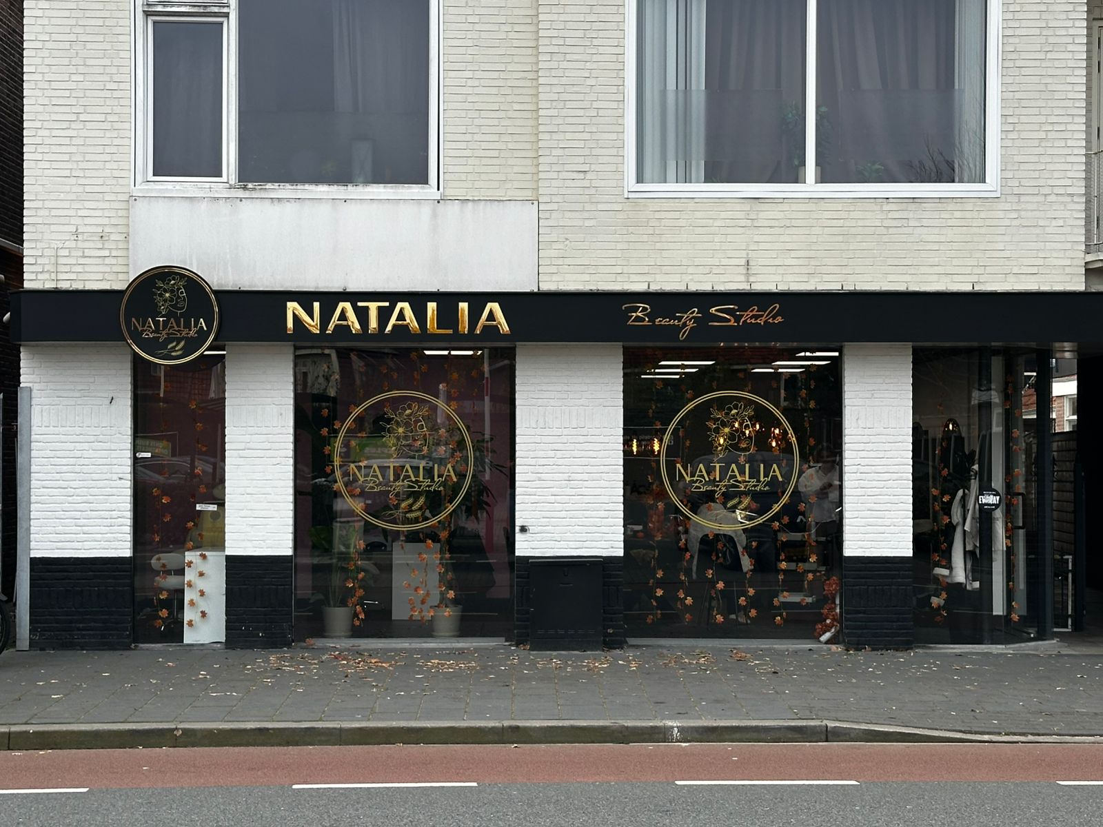 De zwart-witte gevel van Natalia Beauty Studio aan de Bornsestraat in Almelo, met gouden letters en het ronde logo op de ramen