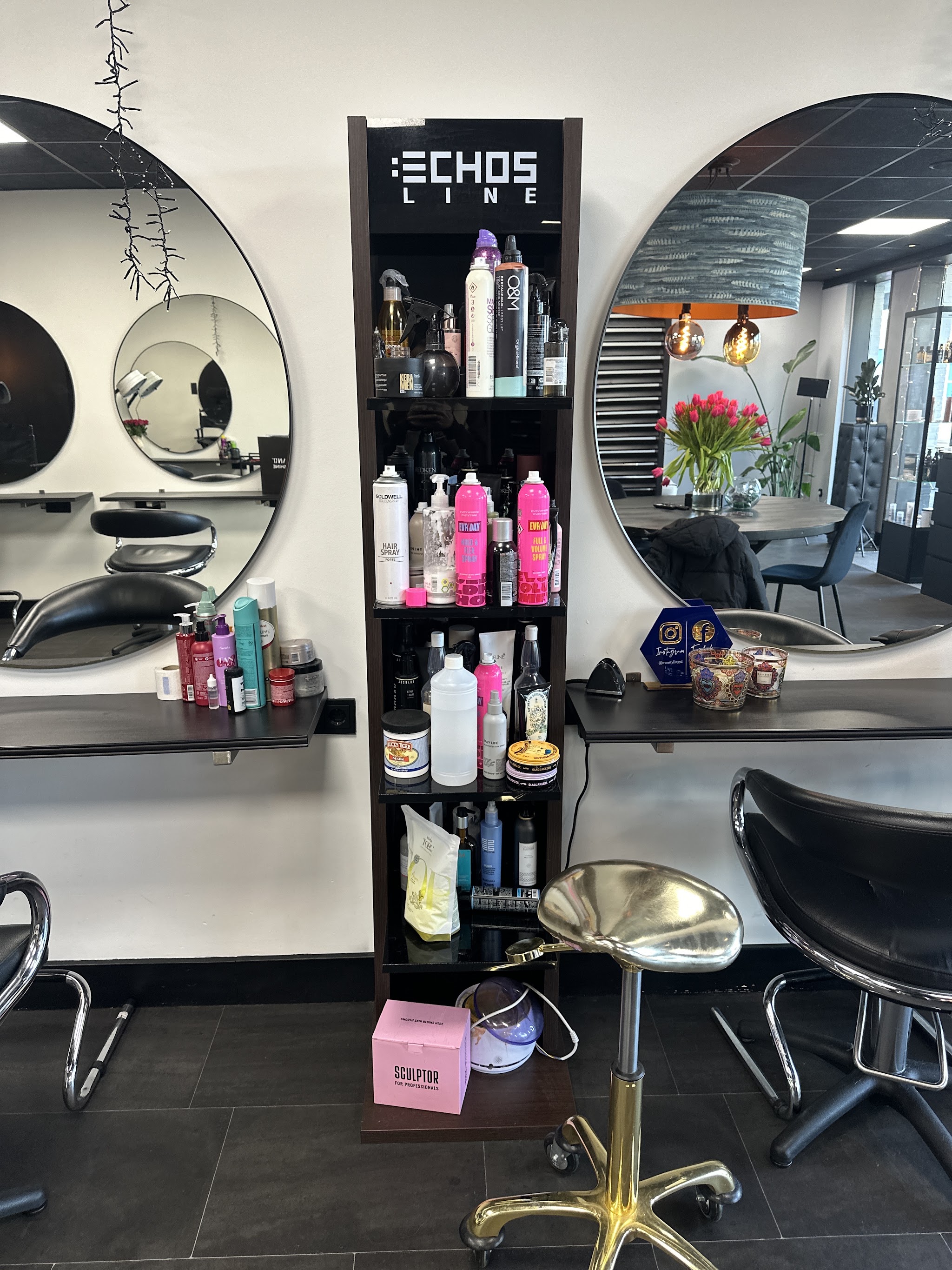 Kapstations met ronde spiegels, een toren met Echos Line haarproducten en zwarte stoelen